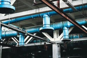 de plafond in de werkplaats Bij de industrieel chemisch petrochemisch machine bouwen raffinaderij met blauw metaal ijzer groot pijpen van inlaat en uitlaat ventilatie foto