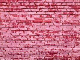 structuur van een mooi uniek ongebruikelijk roze inschrijving oud gebarsten steen muur van rechthoekig bakstenen met naden geschilderd met roze oud haveloos verf. de achtergrond foto