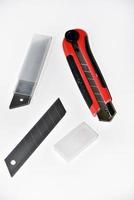 rood schrijfbehoeften mes met messen Aan een wit achtergrond. snijdend gereedschap met messen Aan een wit achtergrond. foto