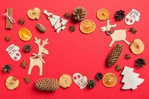 top visie van rood achtergrond versierd met feestelijk speelgoed en Kerstmis symbolen rendieren en nieuw jaar bomen. vakantie concept met kopiëren ruimte foto