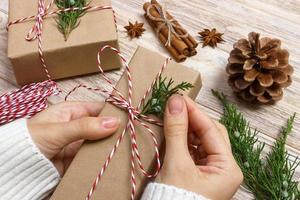 handen van vrouw decoreren Kerstmis geschenk doos foto