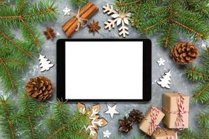 digitaal tablet bespotten omhoog met rustiek Kerstmis grijs cement achtergrond decoraties voor app presentatie. top visie met kopiëren ruimte foto