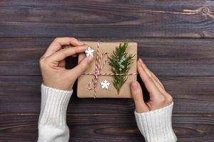 handen van vrouw decoreren Kerstmis geschenk doos foto