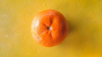 top hoek, vers oranje fruit Aan een geel achtergrond foto