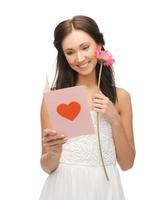 jonge vrouw met bloem en briefkaart foto