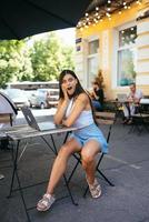 verrast jong vrouw zittend in een straat cafe foto