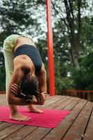 een jong vrouw in aan het doen yoga in de werf foto