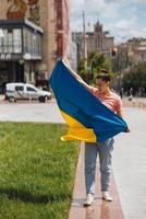 jong vrouw met nationaal vlag van Oekraïne Aan de straat foto
