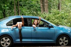 twee vriendinnetjes dwaas in de omgeving van en lachend samen in een auto foto