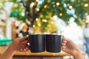 detailopname beeld van een mensen gerinkel koffie cups samen in cafe foto