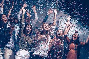 ze liefde hebben plezier. groep van mooi jong mensen het werpen kleurrijk confetti en op zoek gelukkig foto