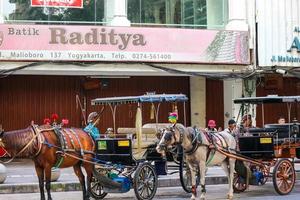 yogakarta, Indonesië Aan oktober 23, 2022. andong of door paarden getrokken vervoer met haar koetsier geparkeerd Aan jalan malioboro, aan het wachten voor passagiers. foto