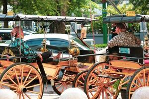 kant visie van de wisselwerking van de wagon of andong chauffeurs Aan jalan malioboro, yogakarta. met typisch Javaans batik kleren en blangkon hoeden foto