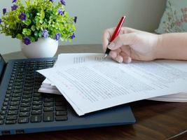 hand- Holding rood pen Aan papierwerk foto