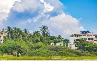 palmen parasols zon ligstoelen strand toevlucht zicatela puerto escondido Mexico. foto