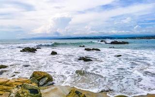 mooi surfer golven rotsen kliffen Bij strand puerto escondido Mexico. foto