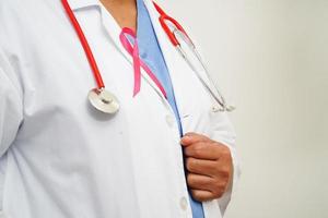 Aziatisch vrouw dokter met roze lint, wereld borst kanker dag Bij oktober. foto