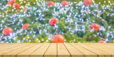 leeg hout tafel top met vervagen Kerstmis boom met bokeh licht achtergrond foto