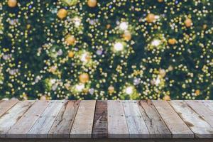 leeg hout tafel top met vervagen Kerstmis boom met bokeh licht achtergrond foto