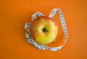 een appel en een centimeter plakband foto
