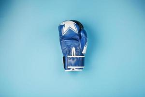 een paar- van boksen blauw handschoenen geconfronteerd elk andere Aan een blauw achtergrond. foto