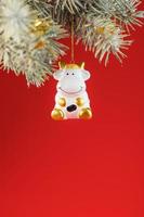 een beeldje van een koe Aan een Kerstmis kaart Aan een rood achtergrond, vrij ruimte voor tekst. foto