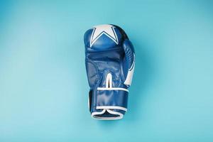 blauw boksen handschoen Aan een blauw achtergrond met vrij ruimte foto