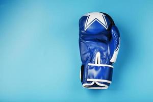 blauw boksen handschoen Aan een blauw achtergrond met vrij ruimte foto