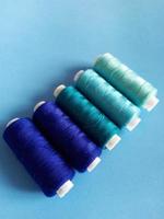 draden voor naaien in blauw kleuren Aan een licht blauw achtergrond foto