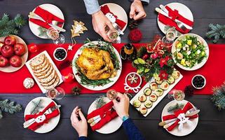 gebakken kalkoen. Kerstmis diner. de Kerstmis tafel is geserveerd met een kalkoen, versierd met helder klatergoud en kaarsen. gebakken kip, tafel. familie diner. top visie foto