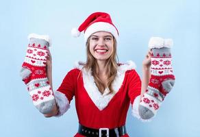 detailopname van Kaukasisch gelukkig vrouw vervelend de kerstman kleren Holding paar van Kerstmis sokken foto