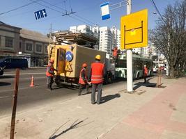 weg arbeiders in Jurken, overall en bouw helmen werk Aan repareren de weg Aan de straat, de weg foto