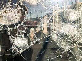 de structuur van de gebroken gebarsten dik breekbaar gebroken scherp glas, triplex met glimmend klein fragmenten. de achtergrond foto