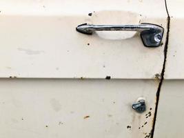een oud retro wijnoogst hipster roestig geoxideerd chroom metaal zilver deur knop met een retro knop voor een antiquan wit Amerikaans passagier auto van de jaren 60, jaren 70, jaren 80, jaren 90, jaren 2000 foto