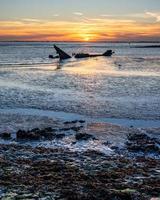 zonsondergang achter de schipbreuk van de James duffy, hansweert de Nederland foto