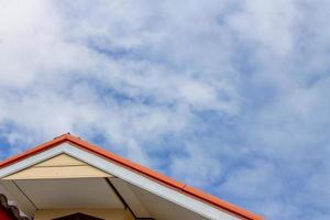 rood eik en bruin geveltop dak isoleren Aan blauw lucht met wolken. foto