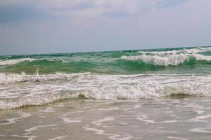 wit zacht Golf Aan leeg tropisch strand en blauw zee met blauw lucht foto
