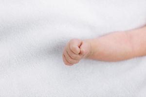 detailopname van pasgeboren baby meisje hand- Aan wit deken buitenshuis. moederschap en kinderjaren concept. selectief focus foto