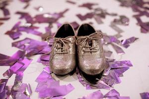 stijlvolle babyschoenen op witte achtergrond met kleurrijke confetti een copyspace. plaats voor inschrijving. foto