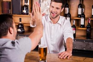 het is mooi zo naar zien u opnieuw achterzijde visie van mannetje klant pratend naar barman terwijl zittend Bij de bar teller foto