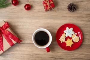 vrolijk Kerstmis met eigengemaakt koekjes en koffie kop Aan hout tafel achtergrond. Kerstmis vooravond, partij, vakantie en gelukkig nieuw jaar concept foto