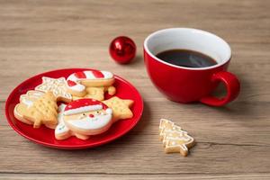 vrolijk Kerstmis met eigengemaakt koekjes en koffie kop Aan hout tafel achtergrond. Kerstmis vooravond, partij, vakantie en gelukkig nieuw jaar concept foto