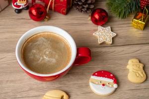 vrolijk Kerstmis met eigengemaakt koekjes en koffie kop Aan hout tafel achtergrond. Kerstmis vooravond, partij, vakantie en gelukkig nieuw jaar concept foto