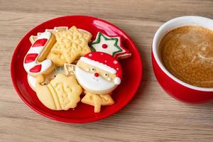 vrolijk Kerstmis met eigengemaakt koekjes en koffie kop Aan hout tafel achtergrond. Kerstmis vooravond, partij, vakantie en gelukkig nieuw jaar concept foto