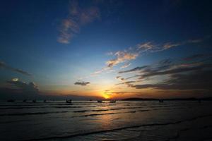 silhouet van schip en lang staart boot Aan zee of oceaan met blauw lucht en wolk Bij zonsondergang, zonsopkomst of schemering tijd Bij krabi, Thailand. schoonheid in natuur met Golf en vervoer concept foto