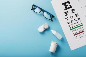 oogheelkundig accessoires bril en lenzen met een oog test tabel voor visie correctie Aan een blauw achtergrond foto