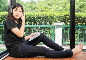 meisje luistert naar de muziek van een digitale tablet foto