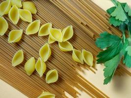 spaghetti van twee types Aan de tafel. schelpen en boekweit pasta. Italiaans voedsel. lang pasta. Koken voedsel. foto