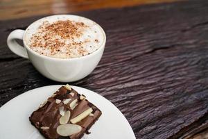 heet cappuccino in wit kop met houten achtergrond, koffie is een populair drinken allemaal over- de wereld. foto