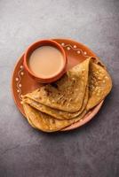 chai paratha - heet thee geserveerd met flatbread is een traditioneel gemakkelijk maaltijd van Indië en Pakistan foto